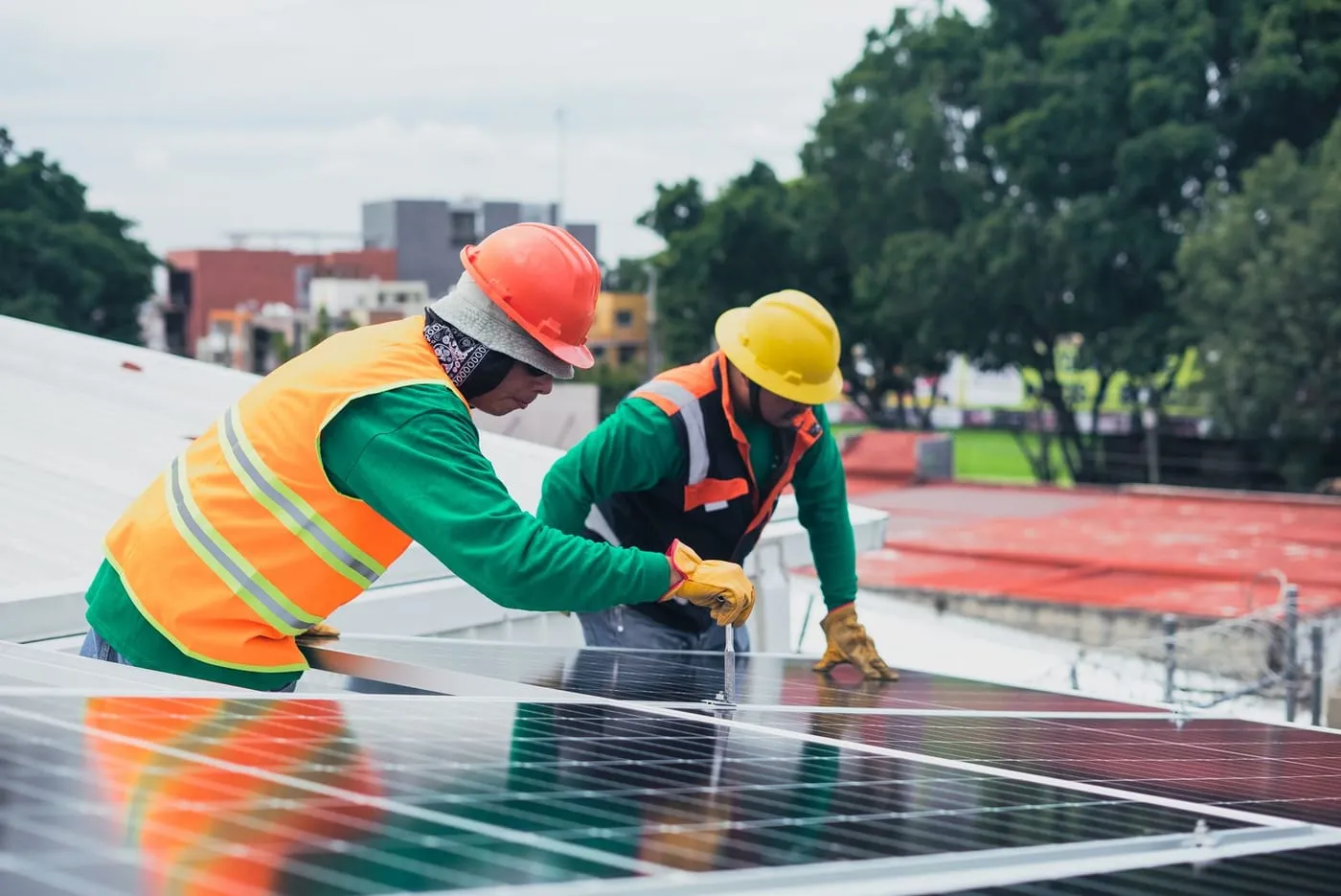 Dos técnicos instalando paneles solares en equipo sobre un techo