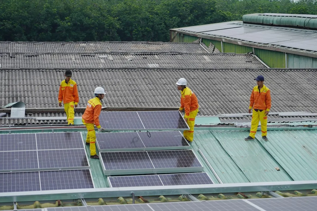 Trabajadores instalando paneles solares en un techo residencial